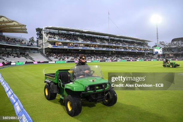 Ground staff work on the pitch as rain delays play during The Hundred match between London Spirit Men and Southern Brave Men at Lord's Cricket Ground...