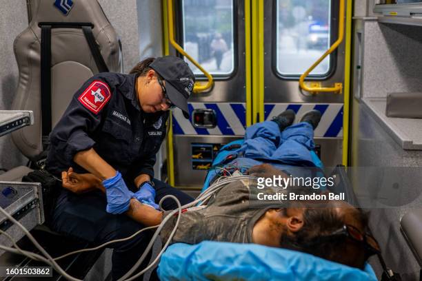 An Austin Travis County medic assists a patient in an ambulance on August 08, 2023 in Austin, Texas. EMT were called after the patient was found...