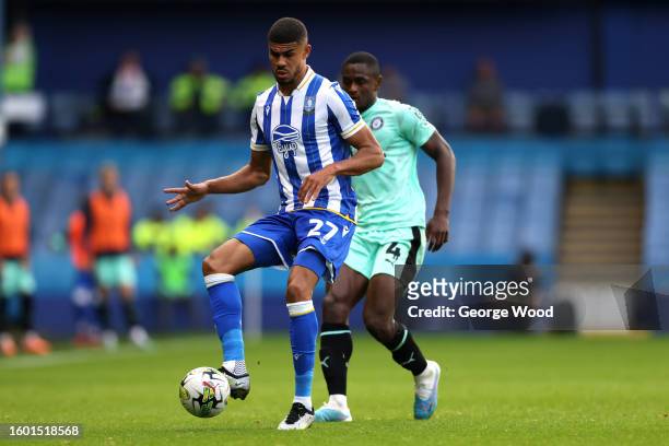 Ashley Fletcher of Sheffield Wednesday plays a pass ahead of Akil Wright of Stockport County during the Carabao Cup First Round match between...