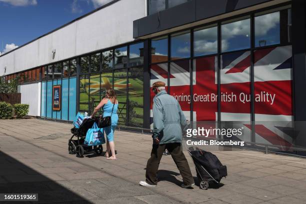 Shoppers outside an Aldi Stores Ltd. Supermarket in Strood, UK, on Tuesday, Aug. 15, 2023. Grocery price inflation has fallen sharply, another sign...