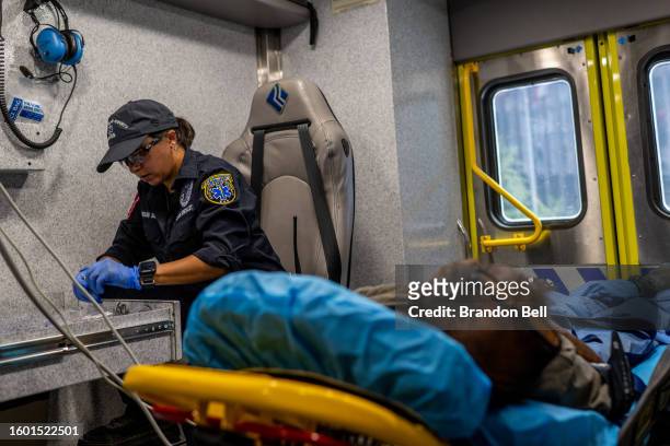 An Austin-Travis County medic assists a patient in an ambulance on August 08, 2023 in Austin, Texas. EMT were called after the patient was found...