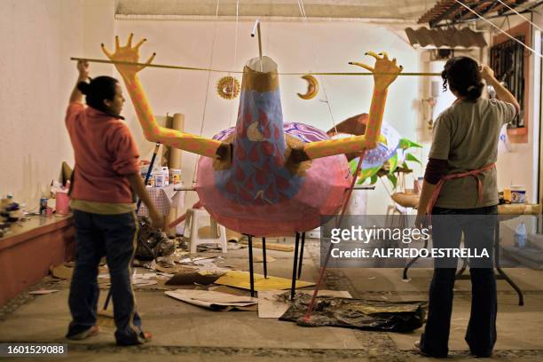 Mexican craftswoman Elsa Linares and assitant Yeudiel Lara work on an "alebrije" called "Head of Bird and Feet of Goat" in Mexico City for the "Night...