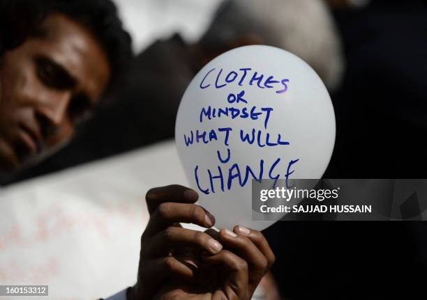 An Indian protestor holds a balloon with a slogan during a protest against last month's gang rape and murder of a student, in New Delhi on January...