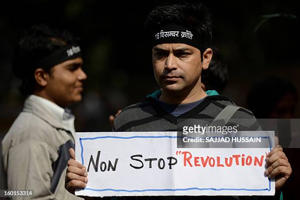 An Indian protestor holds a placard during a protest against last month's gang rape and murder of a student, in New Delhi on January 27, 2013....