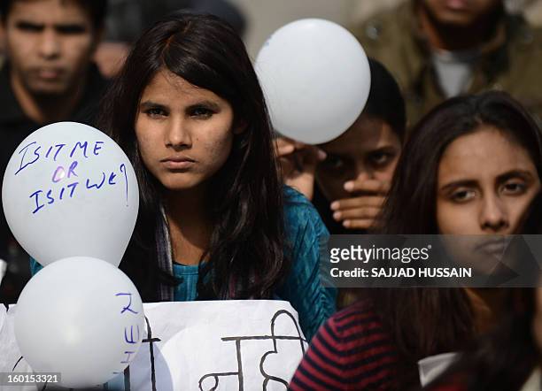 Indian protestors holds balloons with slogans during a protest against last month's gang rape and murder of a student, in New Delhi on January 27,...
