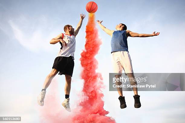 Basketball players jumping to smoking ball