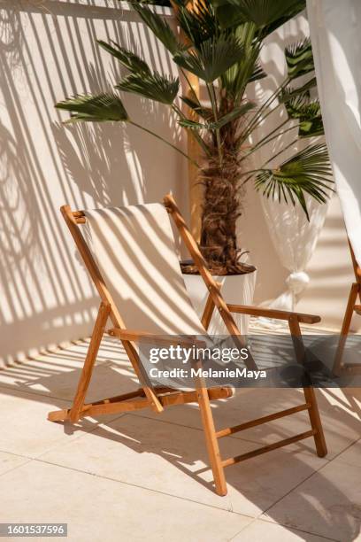 boho-liegestühle unter treibholz-pergola am pool in warmem sonnenlicht - boho-stil stock-fotos und bilder