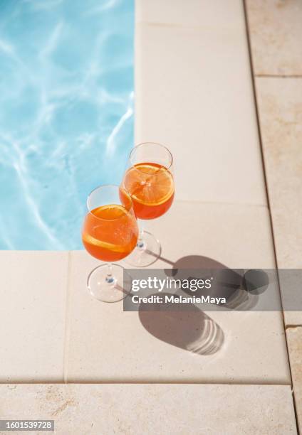 orange spritz glasses by the pool in warm sunlight in the summer - poolside cocktail party bildbanksfoton och bilder