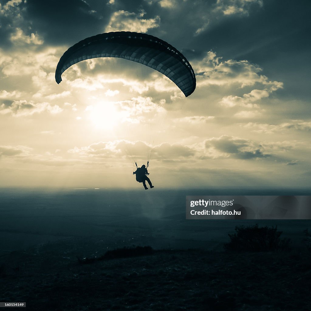 Sunset paragliding with clouds