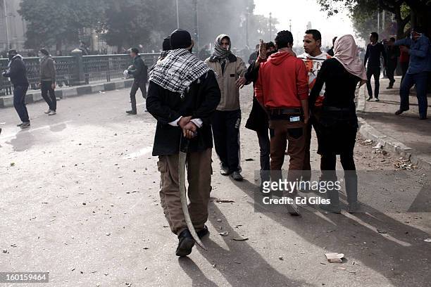 An Egyptian protester holds a homemade sword behind his back during a demonstration in Tahrir Square on January 27, 2013 in Cairo, Egypt. Violent...