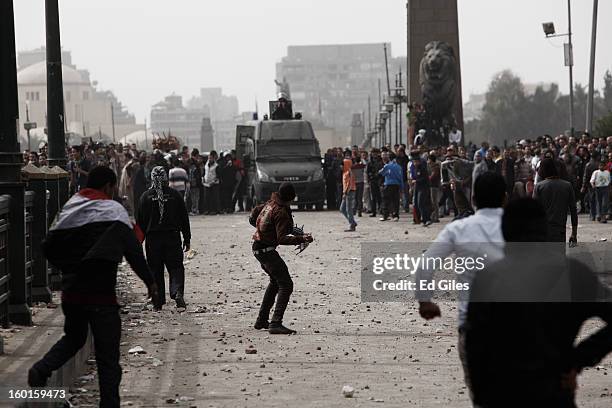 An Egyptian protester throws a rock towards riot police during a demonstration in Tahrir Square on January 27, 2013 in Cairo, Egypt. Violent protests...