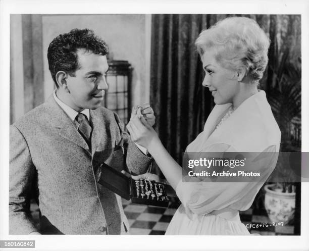 Cantinflas and Kim Novak exchanging item in a scene from the film 'Pepe', 1960.