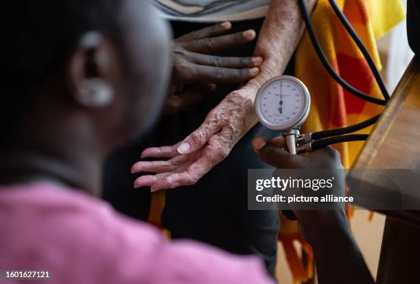 August 2023, Baden-Württemberg, Filderstadt: A trainee nursing specialist in possession of a training visa, performs a blood pressure measurement on...