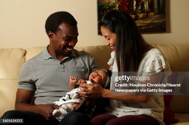 Karina Gonzalez holds her daughter, with her husband, Rupert Edwards III, at their home, Thursday, May 10 in Houston.