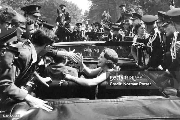 Well-wishers surround the car of Princess Beatrix of the Netherlands and her fiancee Claus van Amsberg , after they announced the date of their...