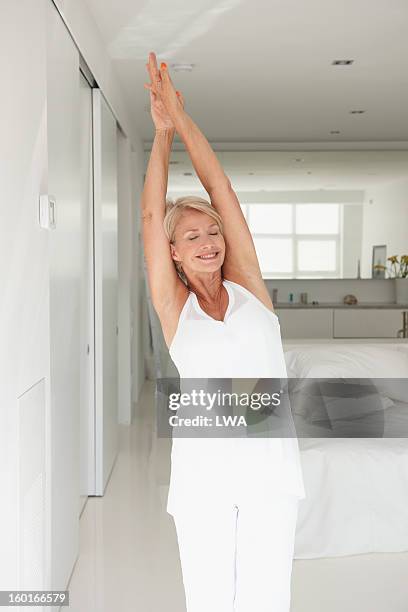 mature woman stretching - stretching home stock pictures, royalty-free photos & images