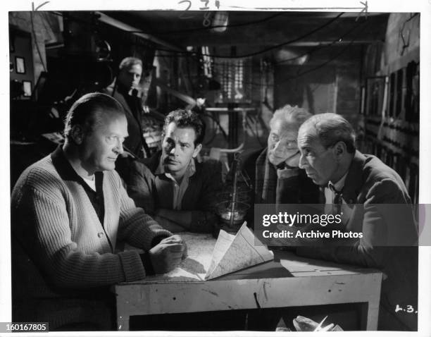 Curd Jürgens talks with Herbert Lom and the rest of his colleagues in a scene from the film 'I Aim At The Stars', 1960.