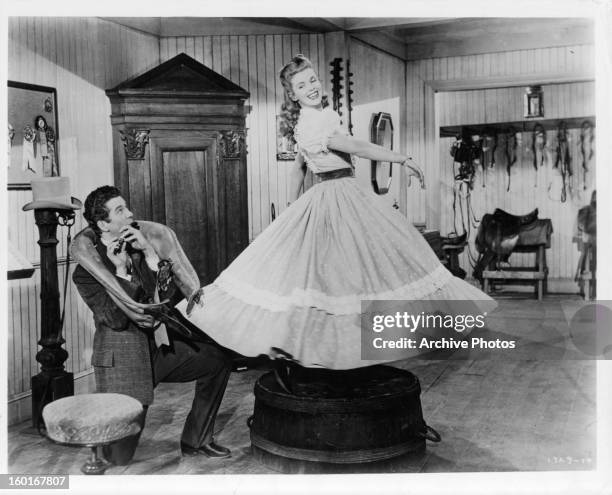 Bill Shirley plays a flute as Eileen Christy twirls in a scene from the film 'I Dream Of Jeanie', 1952.