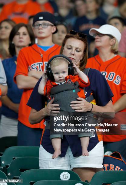 Kristine Bird tries to keep ear protection on her 8 1/2 month-old grandson, Bowie Davis, before the start of an MLB game at Minute Maid Park,...