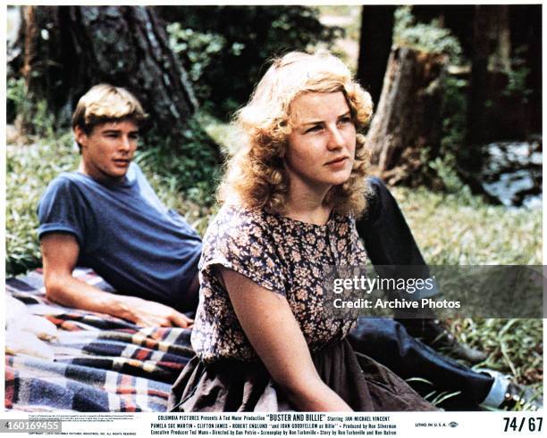 Jan-Michael Vincent and Joan Goodfellow sit outside in a scene from the film 'Buster And Billie', 1974.