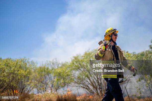 Firefighter prepares to put out a wildfire during an excessive heat warning on August 08, 2023 in Hays County, Texas. The city of Austin and its...