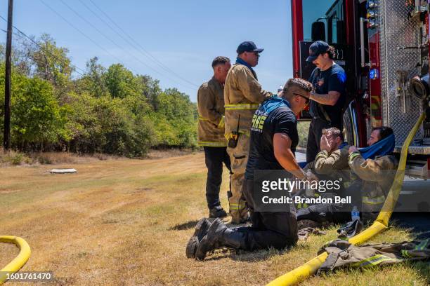 Members of the Hays County Emergency Service Districts and the Kyle and Buda Fire Departments rest together while combatting a wildfire during an...