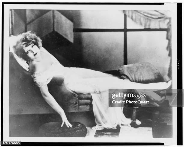 Clara Bow, the 'It' girl, reclining on a chaise, late 1910s or early 1920s.