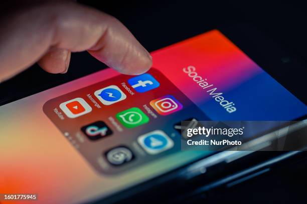 Close - up finger pointing to Facebook mobile app displayed on a smartphone screen alongside that of X,Whatsapp,Telegram,TikTok,Threads, on August 15...