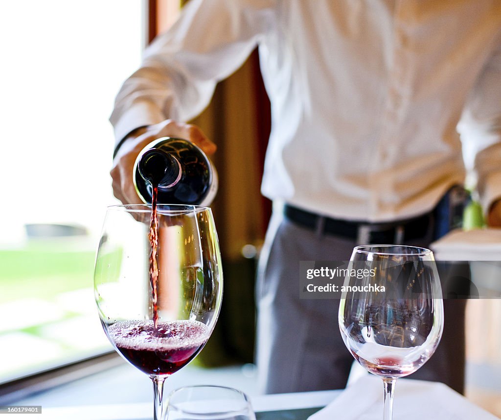 Kellner gießen Rot Wein im Glas