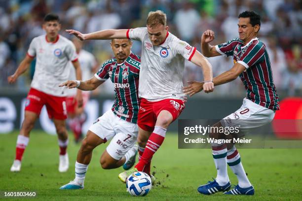 Luciano Gondou of Argentinos Juniors challenges for the ball with André and Paulo Henrique Freitas of Fluminense during the Copa CONMEBOL...