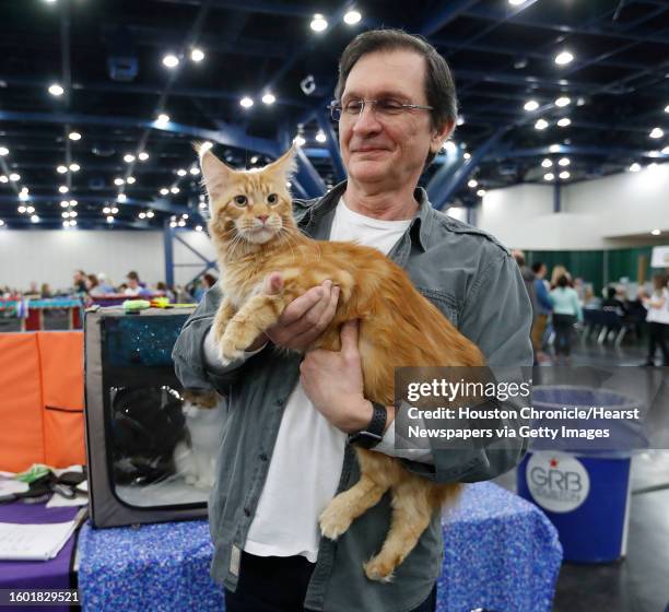 Bruce Farmer holds 8-month-old Wowka, a Maine Coon cat, during the Houston Cat Club's 66th annual Charity Cat Show at the George R. Brown Convention...