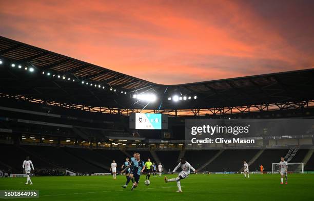 Red sky is pictured as Brooklyn Ilunga of Milton Keynes Dons delivers a cross ahead of Jack Grimmer of Wycombe Wanderers during the Carabao Cup First...