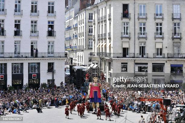Members of the public look at a giant mechanical marionette of Nantes' Royal de Luxe street theatre company performing in Nantes, western France, on...