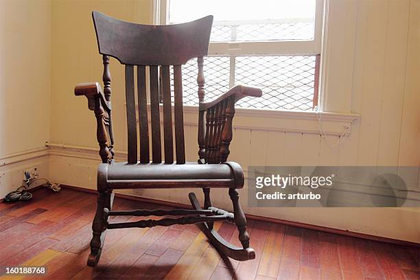 de madeira marrom com iluminação cadeira de balanço com uma janela - cadeira de balanço - fotografias e filmes do acervo