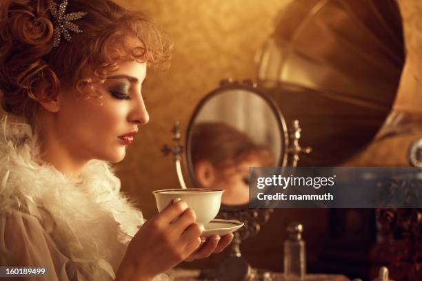 retro beauty drinking coffee in the morning - gold dress stockfoto's en -beelden