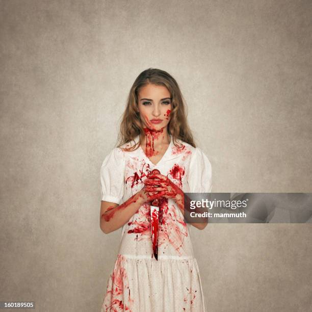 killer beauty holding bloody knife - blood stain stockfoto's en -beelden
