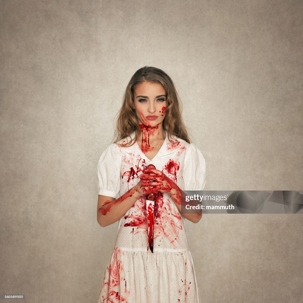 Killer beauty holding bloody knife