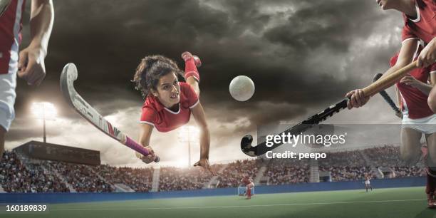 field hockey player diving to hit ball - field hockey player stock pictures, royalty-free photos & images