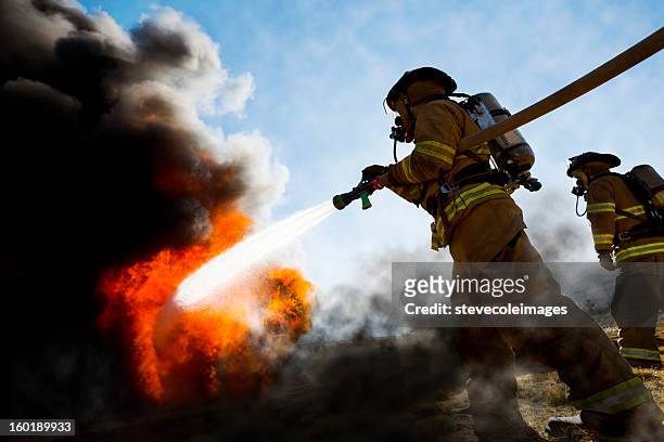 firefighters extinguishing house fire - accidents and disasters stock pictures, royalty-free photos & images