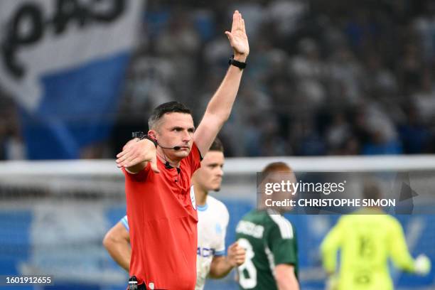 British referee Michael Oliver gestures during the UEFA Champions League second leg of the third qualifying round football match between Olympique...