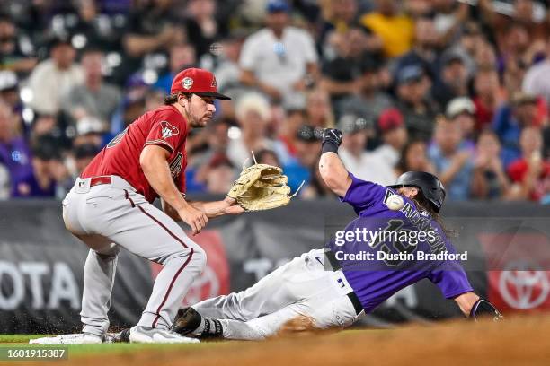 Charlie Blackmon of the Colorado Rockies slides into third base with a triple ahead of the throw to Buddy Kennedy of the Arizona Diamondbacks in the...