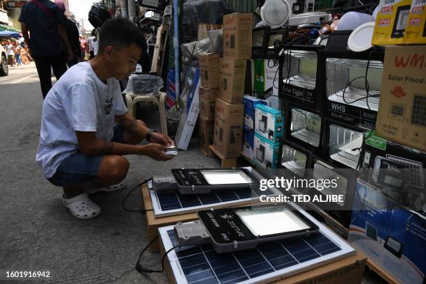 Vendor tests solar-powered house and street lights for sale in Manila on August 16, 2023.