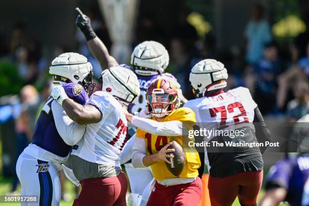 Washington Commanders quarterback Sam Howell scrambles as the pocket collapses during a joint practice with the Baltimore Ravens at the Ravens...