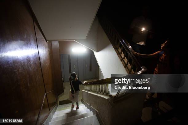 Residents use smartphone torch light to illuminate a staircase during a loadshedding power outage period, in the Dokki district of Giza, Egypt, on...