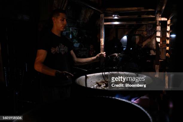 Street vendor fries falafel under smartphone torch light during a loadshedding power outage period, in the Al-Muneera district of Cairo, Egypt, on...