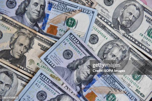 In this photo illustration, several $100 and $50 and $20 bills are displayed on a table.