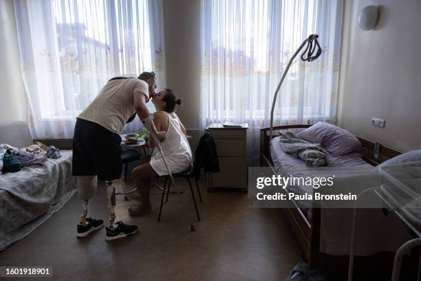 Serhii Kopyshchyk and his wife Svitlana kiss before Serhii heads out to buy something at the supermarket, as newborn baby boy Marko sleeps at the...
