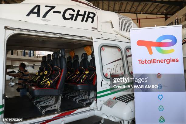 Picture taken on August 16, 2023 shows a helicopter next to the emblem of French oil giant TotalEnergies during the inauguration ceremony of a...