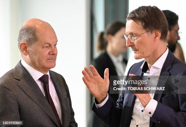 German Chancellor Olaf Scholz and German Health Minister Karl Lauterbach talk prior to the start of the weekly cabinet meeting at the Chancellery in...