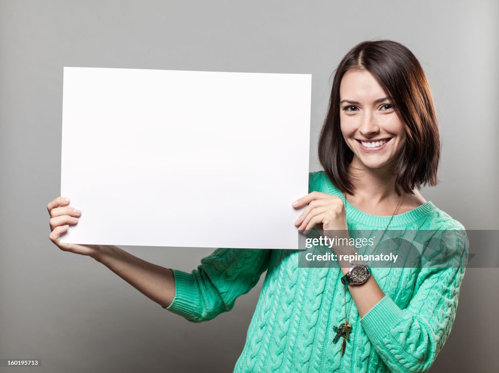 Young brunette woman holding blank sign